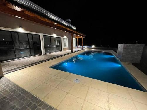 科连特斯Casa Quinta Laguna Brava 2. Bitcoins House.的夜间在房子前面的游泳池