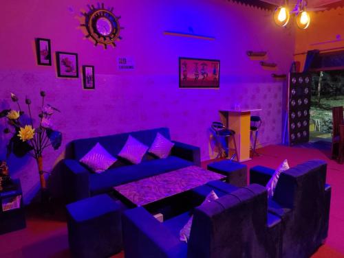 DāngchuraMoupiya Resort and Restaurant的紫色的客房配有一张沙发和一张桌子
