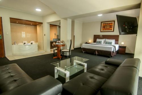 利马Epiqus Hotel的酒店客房配有床、沙发和浴缸。
