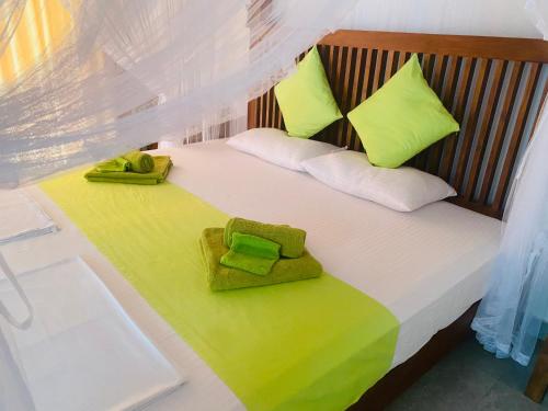 阿鲁特伽马Villa Riverside的一间卧室配有带绿色和白色枕头的床
