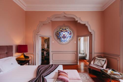 里斯本Torel Palace Lisbon的卧室配有一张床,墙上挂着吊灯