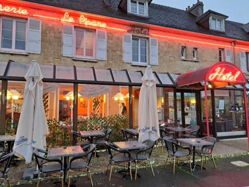 乌伊斯特勒昂Hôtel Le Phare的餐厅前的一组桌子和遮阳伞