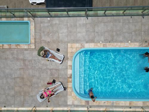 巴拉那州蓬塔尔Hotel Amaromar的游泳池的顶部景色,周围的人坐在游泳池周围
