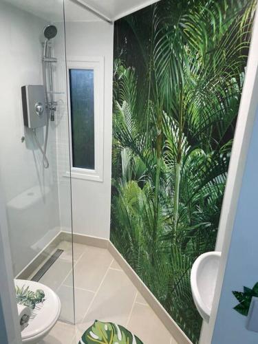 Cosy Jungle Cabin With Bathroom的浴室设有植物壁画和淋浴。