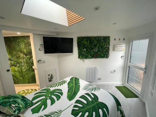 Cosy Jungle Cabin With Bathroom的卧室配有一张挂在墙上的绿色植物床。
