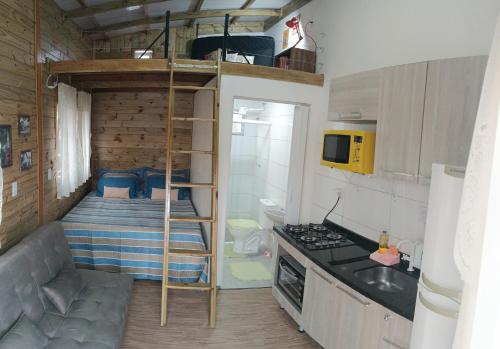 弗洛里亚诺波利斯Dunas Tiny House casa 1的一间小厨房,位于一个小房子内,配有双层床