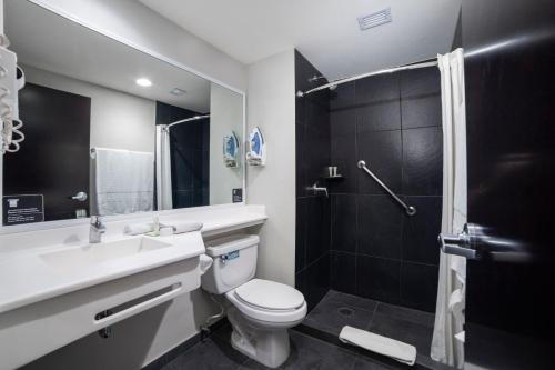 巴亚尔塔港City Express Plus by Marriott Puerto Vallarta的浴室配有卫生间、盥洗盆和淋浴。
