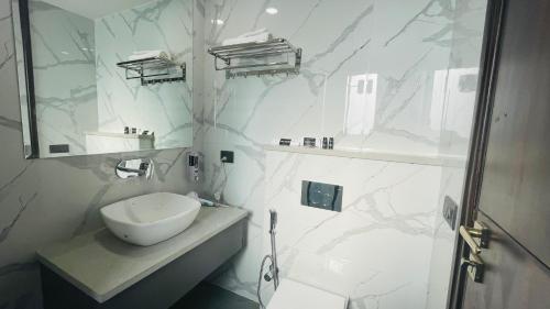 古尔冈Saltstayz Basil - Near Golf Course Road的白色的浴室设有水槽和淋浴。