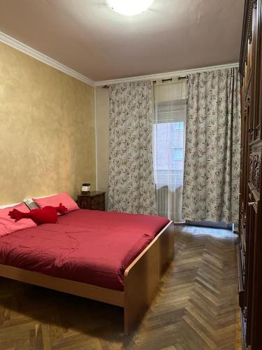 都灵Da Tiziana的一间卧室设有红色的床和窗户。