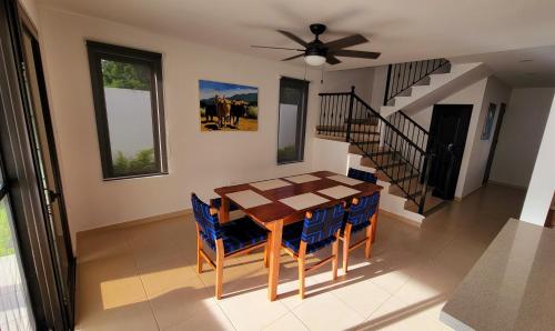 马那瓜New 3 bedroom Home in Managua的一间带木桌和蓝色椅子的用餐室