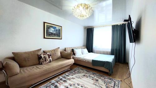 PrigorodnyyАэропорт Астана的带沙发和吊灯的客厅