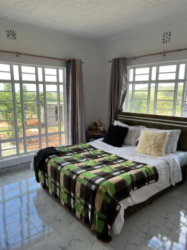 OlolaimutiekNashipae Cultural Oasis的一间卧室配有一张床,床上铺有铺着条纹毯子