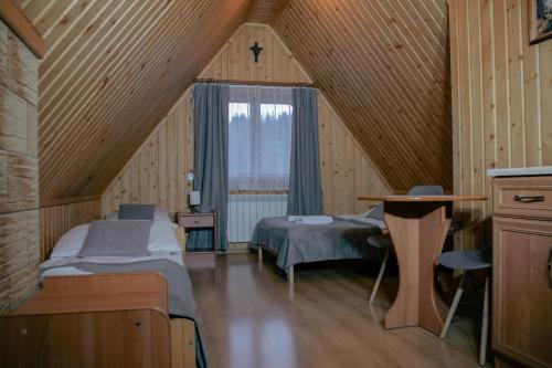 布泽吉Pokoje Gościnne Bożena Dunajczan的一间卧室设有两张床,阁楼上设有窗户。