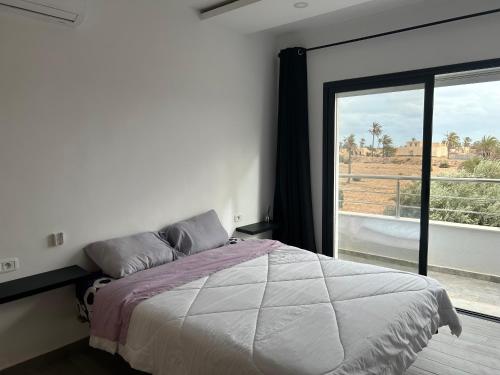米多恩Villa privé 4 chambres 4 lit double à Djerba en face de la ferme de lotos的一间卧室设有一张床和一个大窗户