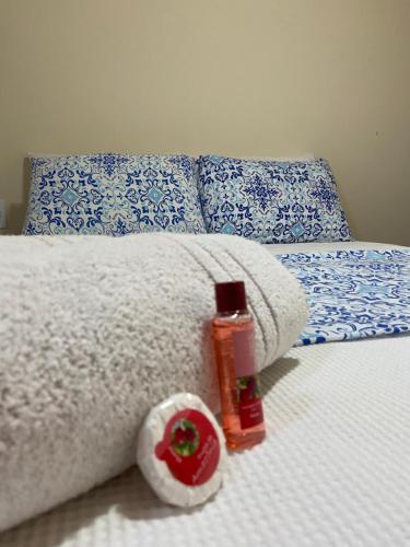 阿布拉奥Recanto da Bruna的一张带白色毯子和一瓶肥皂的床