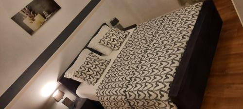 列日Super appartement près des commodités的卧室配有一张带白色床单和枕头的大床。