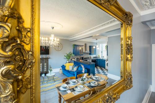 伦敦Stylish & Cosy 3bdr In Fulham with roof terrace的客厅里的金色镜子,配有桌子