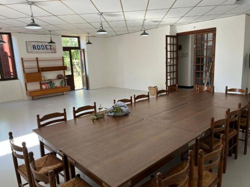 Salles-CuranLa Villa Bouloc, gite pour la famille的大房间设有一张大木桌和椅子