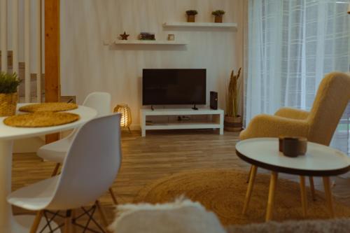 斯克拉斯卡波伦巴Domek na szlaku的客厅配有白色椅子和平面电视