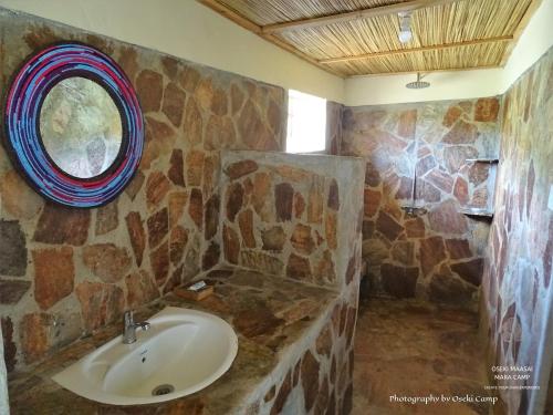 NarokOseki Maasai Mara Camp的一间带水槽和石墙的浴室
