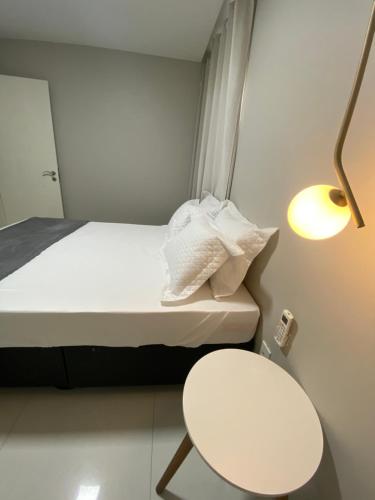 阿拉亚尔-杜卡布Casa Amora的小房间设有床、桌子和灯