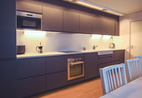 帕亚拉SBC Guest House的厨房配有深紫色橱柜和白色柜台