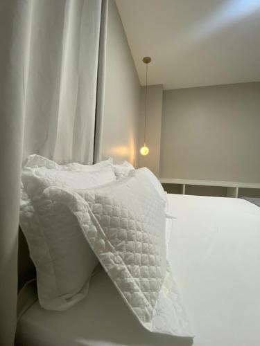 阿拉亚尔-杜卡布Casa Amora的白色的床和白色的棉被