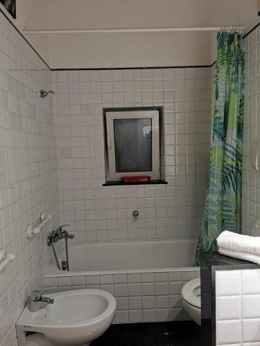 罗马La Casetta的一间带水槽和卫生间的浴室以及一台电视。