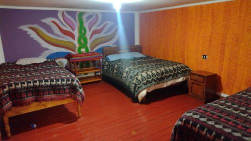 奥兰太坦波Hospedaje La Ñusta的一间卧室设有两张床,墙上挂着一幅画