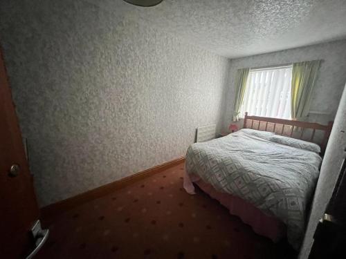 布莱克浦Blackpool Serviced Apartments的一间小卧室,配有床和窗户