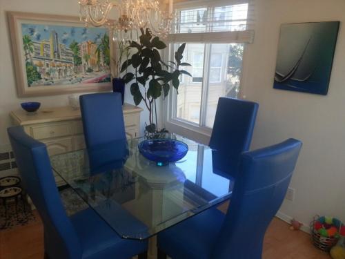 旧金山Centrally located; Walk anywhere!的一间设有玻璃桌和蓝色椅子的用餐室