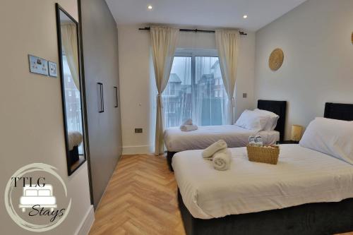 里克曼斯沃斯Newly-Built Urban Retreat by TTLG Stays的酒店客房设有两张床和窗户。