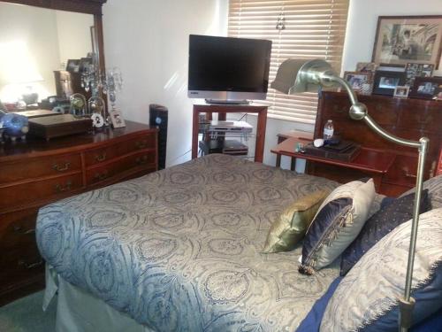 旧金山Entire 2BR, centrally-located, w/parking!的一间卧室配有一张带书桌和电视的床。