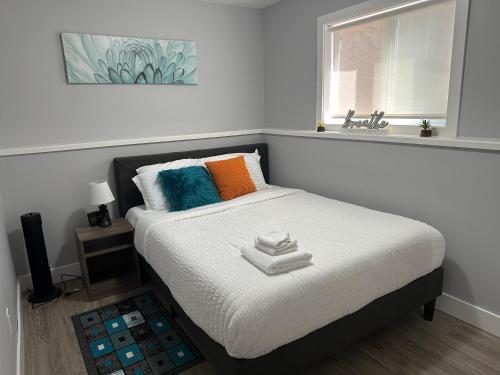 萨斯卡通Exquisite Cozy Suite/full amenities in Kensington的一间卧室设有床、窗户和水槽