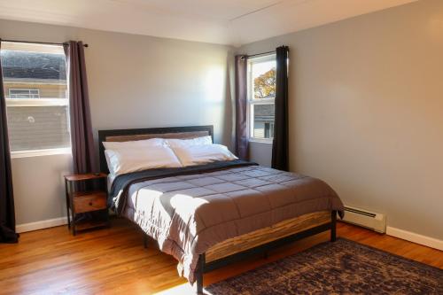 布鲁克林BGI Rentals的一间卧室设有一张床和两个窗户。