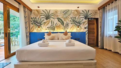 皮皮岛尤瑞普度假酒店的一间卧室配有一张白色大床,铺有热带壁纸