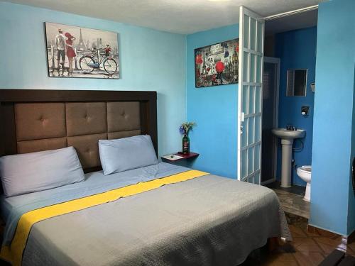 莫雷利亚Estancia María Bonita Morelia的一间蓝色的卧室,配有一张床和一间浴室