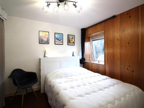 勒蒙多尔Appartement Mont-Dore, 2 pièces, 6 personnes - FR-1-415-149的卧室配有白色的床和黑椅