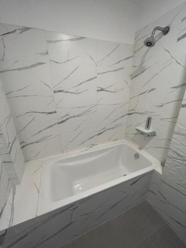 帕纳吉O Abrigo的白色的浴室设有浴缸和大理石墙壁。