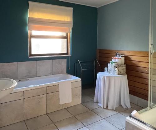 克拉伦斯克拉伦斯乡间公寓的带浴缸的浴室和桌子