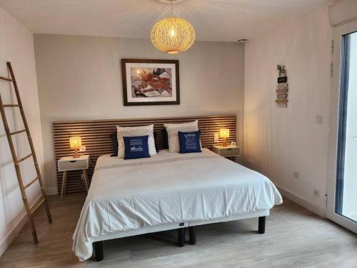 波尔尼谢Maison Vue Mer的一间卧室配有一张带蓝色枕头的大床