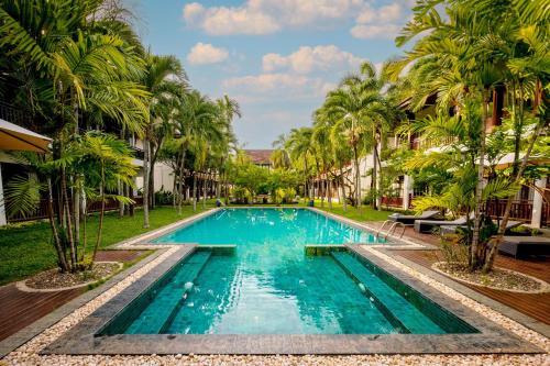 万象绿园精品酒店的棕榈树度假村内的游泳池