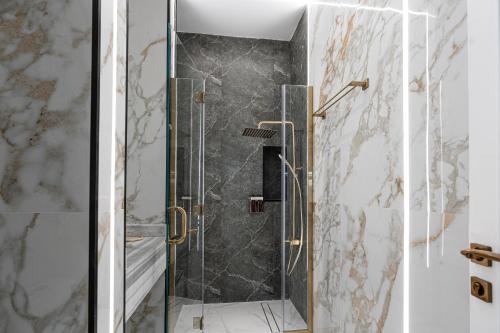 多哈La Maison Resort的浴室里设有玻璃门淋浴