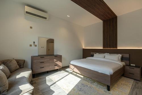 多哈La Maison Resort的一间卧室配有一张床和一张沙发