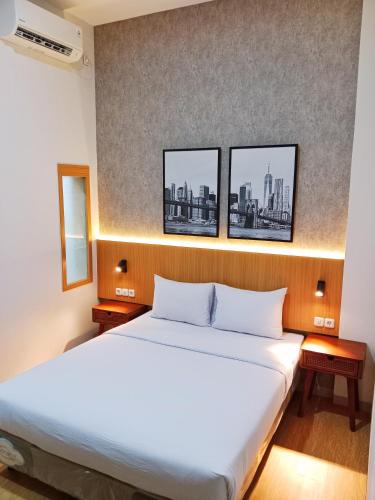 泗水Hotel Andita Syariah的墙上有三张照片的房间的一张床位