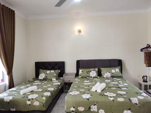 加央Heal Inn Roomstay - Islam Guest的一间卧室配有两张带鲜花的床单