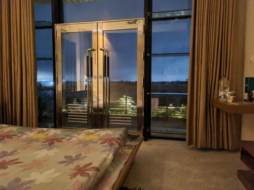 达卡Jolshiri Vacation House的一间卧室设有一张床和一个大型玻璃门