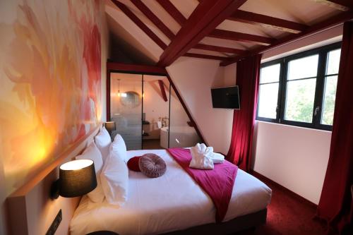 拉旺泽诺Hôtel-SPA Le Moulin De La Wantzenau - Strasbourg Nord的一间卧室配有一张床,上面有两条毛巾