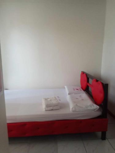 宿务WJV INN JY的一张小床,房间配有红色枕头