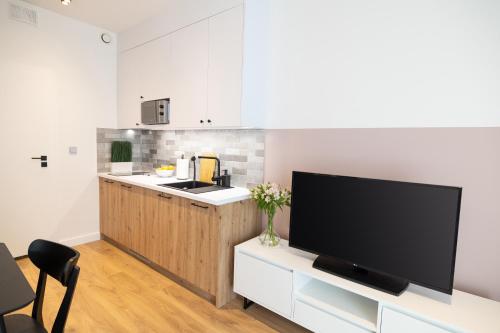 华沙B85 Suites的带电视的客厅和带台面的厨房